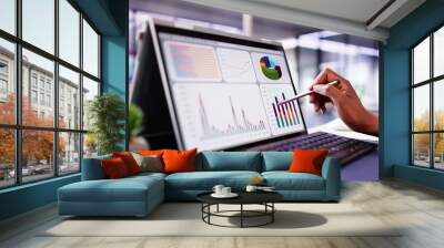 African American woman analyzing financial data on laptop screen Wall mural