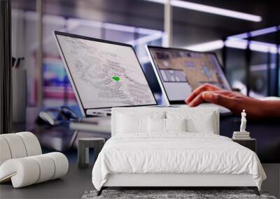 African American woman closely examining cadastral map on laptop screen Wall mural