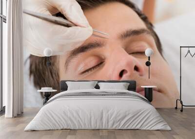 Beautician Hands Plucking Man Eyebrows With Tweezers Wall mural