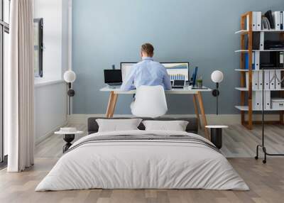 Businessman Analyzing Financial Graphs On Computer At Desk Wall mural