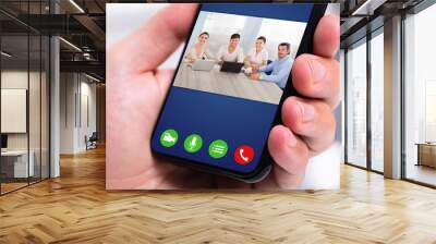 Businessman videochatting on mobile phone Wall mural