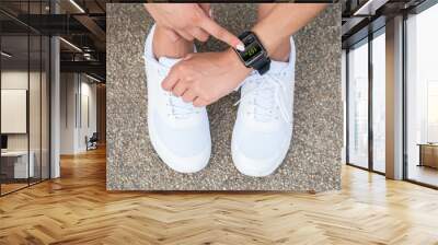 Female Athlete Touching At Smart Watch Showing Heartbeat Rate Wall mural