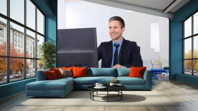 happy businessman using computer in his office Wall mural