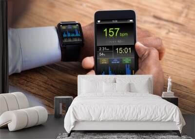 Man With Smartwatch And Cellphone Monitoring Heart Rate Wall mural