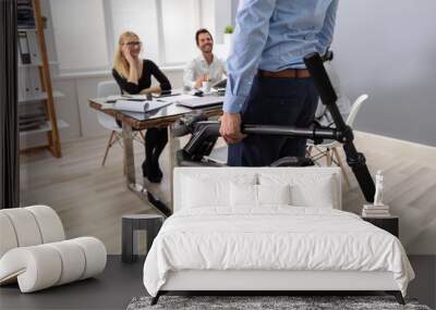 Person Carrying Electric Scooter In Folded Position At Office Wall mural