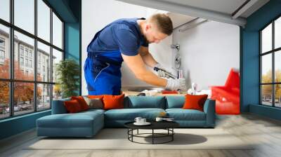 Plumber Fixing Faucet In Kitchen Wall mural