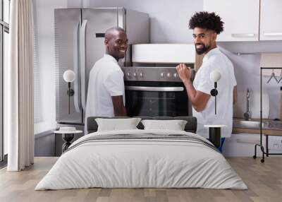 Two Male Workers Placing The Oven In The Kitchen Wall mural