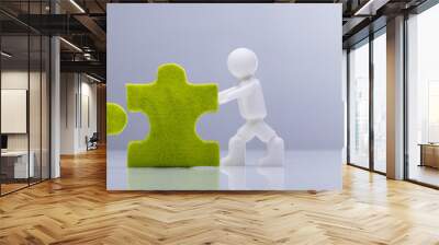 Two Miniature Human Figures Solving Green Jigsaw Puzzles Wall mural