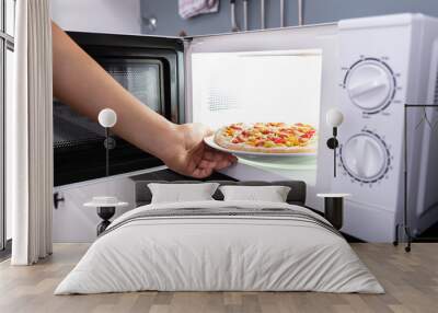 Woman Baking Pizza In Microwave Oven Wall mural