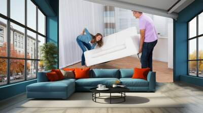 Woman Suffering From Backache While Moving Sofa Wall mural