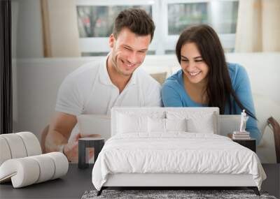 Young Couple Holding Green House Model Wall mural