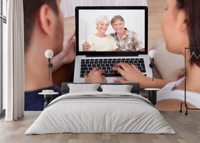 young couple using calling parents Wall mural