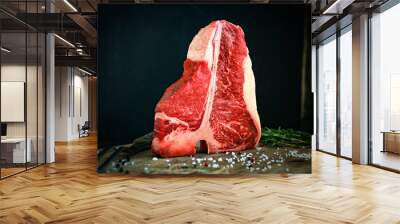 raw t bone steak on wooden Board and black background Wall mural