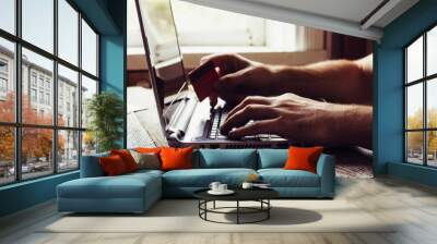 Man Hands holding credit card and using laptop in the evening. Online shopping and online marketing. shallow depth of field, toning photo Wall mural