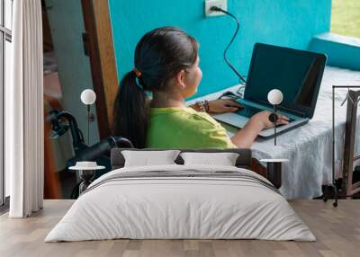 Young Woman in Wheelchair Using Laptop to Work and Study, Highlighting Technology for Low-Income Households Wall mural