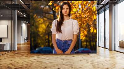 Autumn portrait of a young girl in oak leaves Wall mural