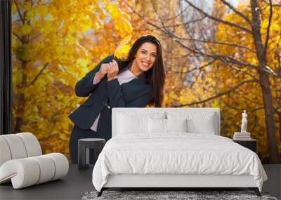 Happy arab businesswoman in blue suit walking in autumn park Wall mural