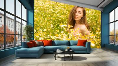 Sexy brunette young woman in chamomile field Wall mural