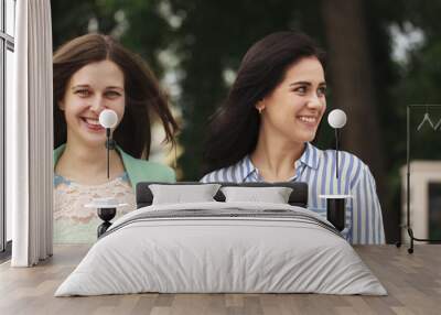 Two happy women walking in the summer park Wall mural