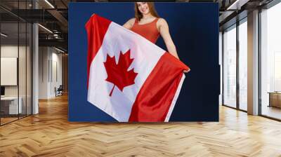 Young woman holding a large Canadian flag Wall mural