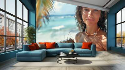 Portrait of a very beautiful young woman relaxing on a beautiful beach with a coconut in her hands. Tropical cocktail. The concept of a luxury vacation at sea Wall mural