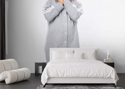 Surprise, question, fright. A 2-year-old boy looks expressively into the camera with his hands folded at his face on a white background. Wall mural