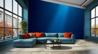 Light blue ray of light shines vertically on blue textured grungy background Wall mural