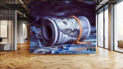 In the dark on broken money is a roll of dollars lit by a ray of light. Wall mural