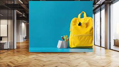 Yellow Backpack and School Supplies on Blue Background Wall mural