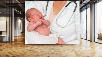 Pediatrician doctor is holding newborn baby in arms Wall mural