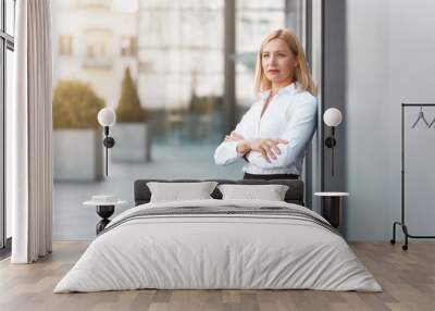 Beautiful adult secretary stands at a break near an office building Wall mural