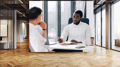 Business meeting in office. Employment interview. Two business partners are talking while sitting at the table. Wall mural