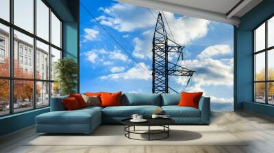 High voltage electricity pylon and transmission power line on the blue sky and white clouds on the background. Parts of electrical equipment and high voltage power line insulators. Wall mural