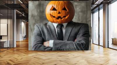 A man in a suit with a carved pumpkin for a head poses confidently Wall mural