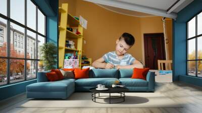 A school-age boy does homework at home. Training at school Wall mural