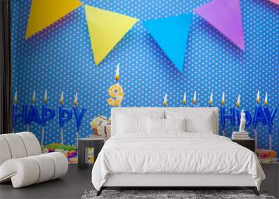 A word made from the letters of happy birthday candles for a nine year old child. Copy space Happy birthday greetings for 9 year old, lit candles with holiday decorations. Beautiful holiday card Wall mural