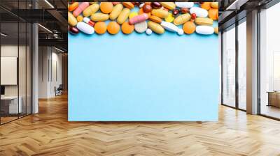 assorted pills and tablets top border over blue background. above view. pharmaceutical concept Wall mural