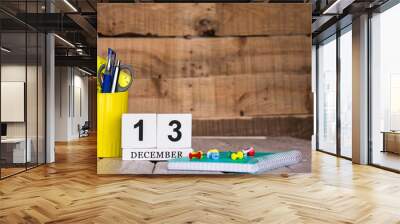 December calendar background with number  13. Stationery pens and pencils in a case on a wooden vintage background. Copy space notepad with pencils and calendar. Planner place for text. Wall mural