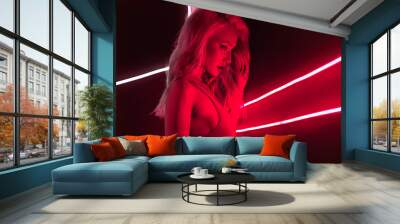 fashion art photo of sexy girl dressed in red in the night-club. Perfect female body with neon lettering on the background Wall mural