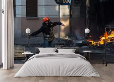 Street protester with a burning Molotov cocktail against a fire Wall mural