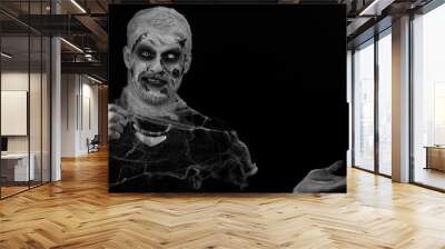 Creepy man with bloody scars face, Halloween stylish zombie make-up. Scary wounded undead guy showing thumbs up and pointing at left on blank space. Place for your advertisement logo. Sinister monster Wall mural