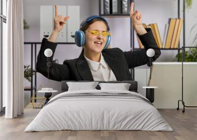 Happy relaxed overjoyed Caucasian business woman working on laptop computer at office wearing headphones listening favorite energetic disco music and dancing. Freelancer girl relaxing, taking a break Wall mural