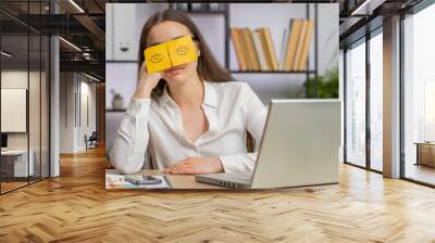 Inefficient tired business woman working sleeping on laptop computer with eyes stickers on face at office workplace desk. Caucasian lazy manager freelancer girl. Business people cheating to sleep Wall mural