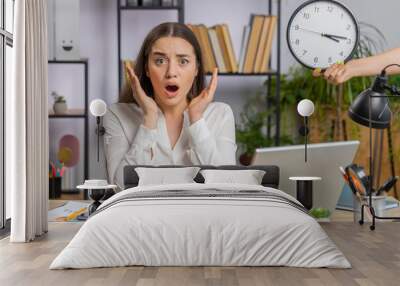 Young business woman working on office laptop with anxiety checking time on clock running late to work being in delay deadline. Manager freelancer girl looking at hour minutes worrying to be punctual Wall mural