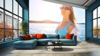 Fashionable beautiful woman relaxing outdoors on the beach. Wall mural