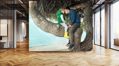 Happy childhood, father and son sit on a tree on a sunny day, fa Wall mural