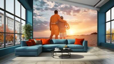 Happy family outdoors summer, Father and Son playing football, energy fun players in soccer in dynamic action have fun playing football in the beach under sunlight. Vacation, holiday concept  Wall mural