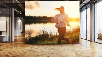 Woman runs in the park on autumn morning. Healthy lifestyle concept, people go in sports outdoors. Silhouette family at sunset. Fresh air. Health care, authenticity, sense of balance and calmness.
 Wall mural