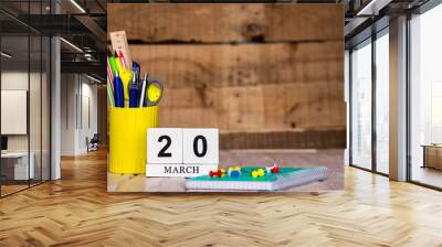 March calendar background with number  20. Stationery pens and pencils in a case on a wooden vintage background. Copy space notepad with pencils and calendar. Planner place for text. Wall mural