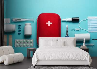 Home first aid kit on a blue background. The elements of the first aid kit are laid out on the table. Wall mural